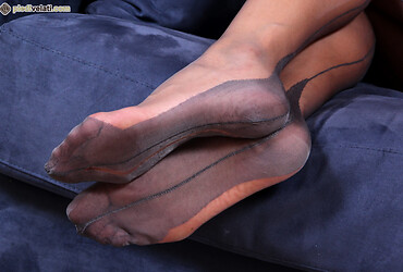 Alessia poses seductively on the couch showing off her gorgeous feet in sheer black pantyhose - Photo #16